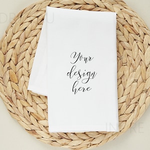 May include: White kitchen towel with the text "Your design here" on a woven straw placemat.