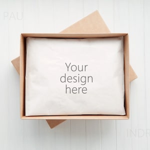 Könnte beinhalten: Ein brauner Karton mit einer weißen Seidenpapierauskleidung. Das Seidenpapier trägt den Text "Your design here".