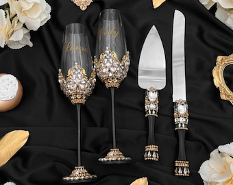 May include: Two black champagne flutes with gold and crystal embellishments, the glasses are personalized with the names "Cody" and "Laura". A black cake server with gold and crystal embellishments is also included.