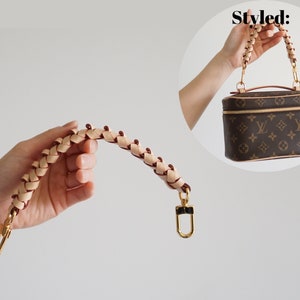 May include: A braided leather strap with gold hardware. The strap is designed to be used as a replacement handle for a handbag.