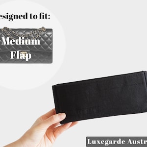 Könnte beinhalten: Schwarzer Filz-Taschenorganizer, der für eine mittelgroße Klappentasche konzipiert ist. Der Taschenorganizer wird in einer Hand gezeigt. Der Text "Luxegarde Australia" ist in der rechten unteren Ecke des Bildes sichtbar.