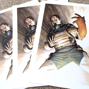 May include: Prints of a science fiction illustration depicting a person in a futuristic uniform, reacting in fear to a glowing, textured object. The artwork features a dramatic use of light and shadow, with a focus on the character's expression and pose.