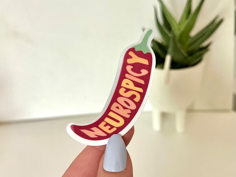 May include: A red chili pepper sticker with the text "Neurospicy" in yellow, orange, and red lettering.