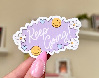 May include: Purple sticker with a white outline and a white 'Keep Going!' message. The sticker has a purple background with two yellow smiley faces, two blue hearts, and two white daisies.