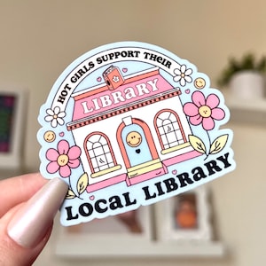 May include: A blue and pink sticker featuring a cartoon library building, flowers, and the text "Hot girls support their local library".