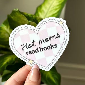May include: A pink and white checkered heart-shaped sticker with the text "Hot moms read books" in black. Two small yellow stars are on the sticker.