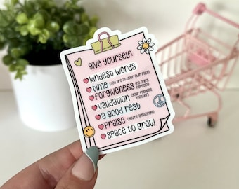 May include: Pink and white sticker with a checklist of things to give yourself, including kindest words, time, forgiveness, validation, a good rest, praise, and space to grow. The sticker has a peace sign, a smiley face, and hearts.