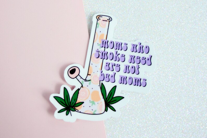 May include: A white sticker with a purple and orange bong design and the text "Moms who smoke weed are not bad moms".
