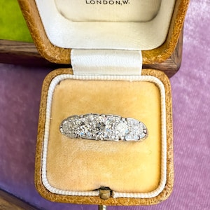Op de afbeelding: Een antieke platina ring met vijf ronde diamanten, gepresenteerd in een vintage Mappin & Webb Ltd. sieradendoosje. Het doosje is gevoerd met cr&egrave;mekleurig fluweel.