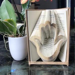 Patrón de plegado de libros con contorno de Hamsa