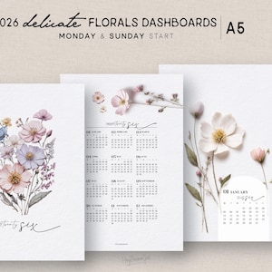 Op de afbeelding: Een set van drie afdrukbare A5-dashboards met bloemmotieven. De dashboards bevatten aquarel illustraties van bloemen in roze, blauwe en paarse tinten. De tekst "2026 Delicate Florals Dashboards" en kalenderindelingen zijn ook inbegrepen.