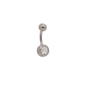 May include: A silver belly button ring with a clear round gem on each end.