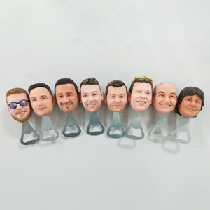 Könnte beinhalten: Acht Flaschenöffner mit verschiedenen Gesichtern auf der Oberseite. Die Flaschenöffner sind aus silbernem Metall mit einem klassischen Flaschenöffner-Design.