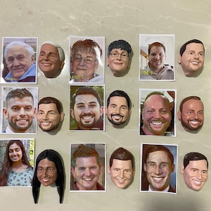 May include: A collection of 18 small, realistic portrait sculptures of people's faces. The sculptures are made of a light brown material and are displayed on a white surface.