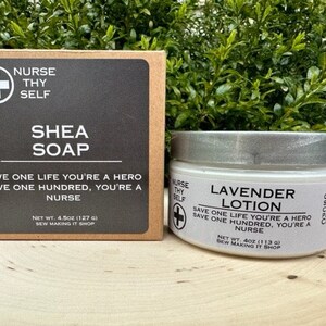 May include: Two jars of body care products with a white background and black text. The jar on the left is labeled "Shea Soap" and the jar on the right is labeled "Lavender Lotion". Both jars have the text "Save one life you're a hero, save one hundred, you're a nurse" and the logo "Nurse Thy Self" with a red cross.