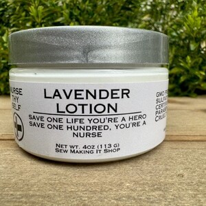 May include: A white jar of lavender lotion with a silver lid. The label reads "Lavender Lotion" and includes the text "Save one life you're a hero, save one hundred, you're a nurse." The jar is 4 oz (113 g) and is made by Sew Making It Shop.