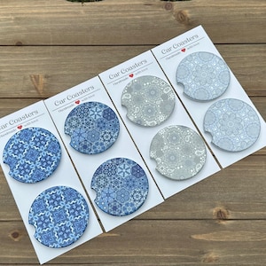 May include: Six blue and white patterned car coasters with the text "Car Coasters Handmade with love" on each card.