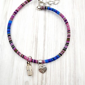 Puede incluir: Un collar tejido para perro de colores vivos con un dije de plata que dice "Mejor amigo" y un dije cilíndrico de plata.