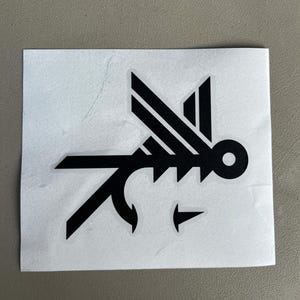 Może przedstawiać: Czarno-biała naklejka z  stylizowanym wzorem latającej ryby.