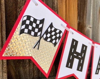 May include: Red and white banner with the word "Happy" in black letters with a black and white checkered flag on each side. The banner has a silver diamond pattern on the back.