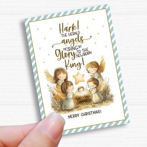 May include: A rectangular Christmas card featuring a nativity scene with angels, a star, and the text "Hark! The herald angels sing glory to the newborn King!" The card has a light blue and gold border and the words "Merry Christmas!"