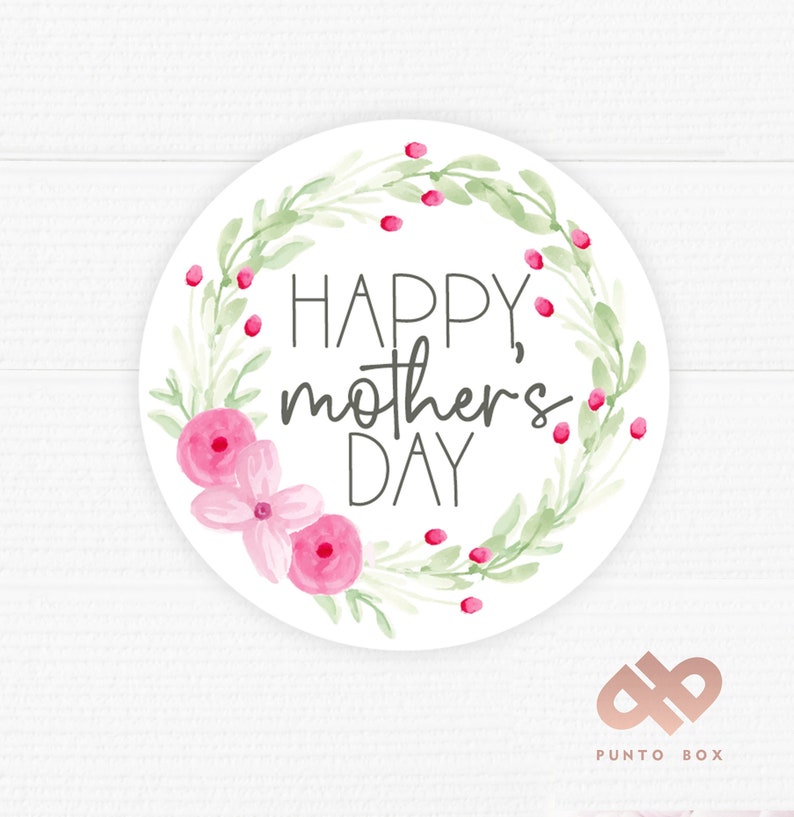 May include: A circular sticker featuring the text "HAPPY, mother's DAY" in black script, encircled by a watercolour wreath of green leaves, pink flowers, and red berries. The background is white.