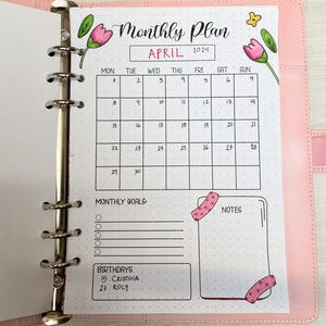 Puede incluir: Un planificador mensual para abril de 2024 con una cuadrícula de calendario, espacio para objetivos mensuales, notas y cumpleaños. El planificador está decorado con ilustraciones florales.