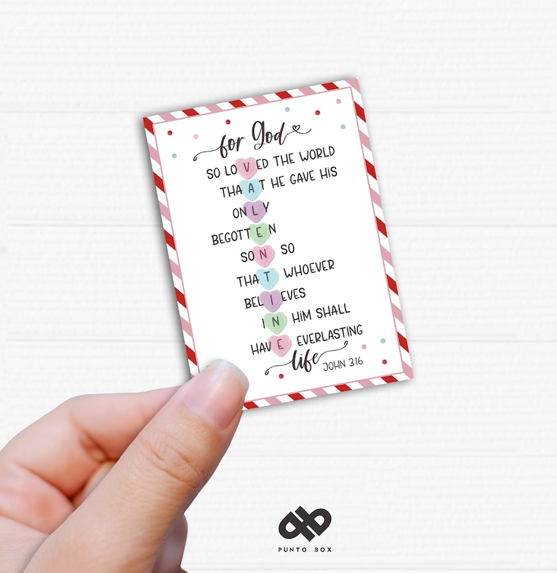 May include: A pink and white card with the words "for God" in a heart shape. The card has a list of words with hearts in place of some of the letters. The text on the card reads: "for God so loved the world that he gave his only begotten son so that whoever believes in him shall have everlasting life John 3:16"