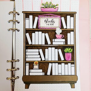 Puede incluir: Una estantería de madera marrón con cinco estantes llenos de libros blancos. El estante superior tiene un cartel rosa que dice "Books I've Read". Hay una planta en maceta rosa en la parte superior de la estantería y una taza de té rosa con vapor en el segundo estante.