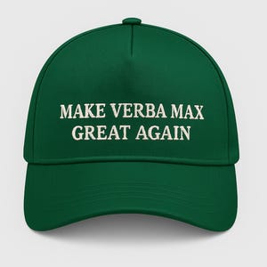 May include: A green baseball cap with the embroidered text "MAKE VERBA MAX GREAT AGAIN" in white. The cap has a curved peak and a button on top. The hat is a solid, vibrant green colour.