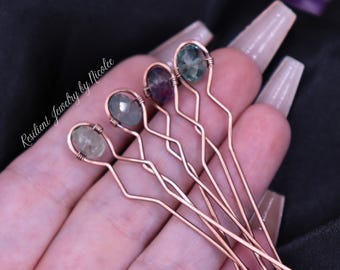 May include: Five copper wire hair pins, each featuring a unique faceted oval gemstone at the top. The wire is bent into a wavy pattern and wrapped around the base of each stone. The text Resilient Jewelry by Nicolee is visible on the left.