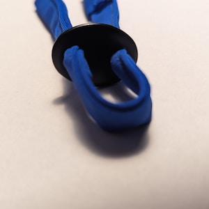 May include: A blue adjustable strap with a black plastic buckle. The strap is made of a soft, flexible material.