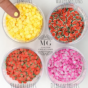 May include: Four clear containers filled with colorful fruit-shaped polymer clay charms. The containers are labeled "Lemons", "Watermelons", "Strawberries", and "Dragon Fruits".