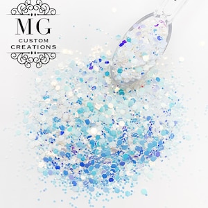 May include: A close-up of iridescent blue and white glitter, with a small spoon filled with the glitter. The glitter is perfect for crafting and adding sparkle to projects.