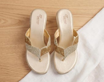 Elegantes sandalias de tacón con tira en V y pedrería bicolor en oro.