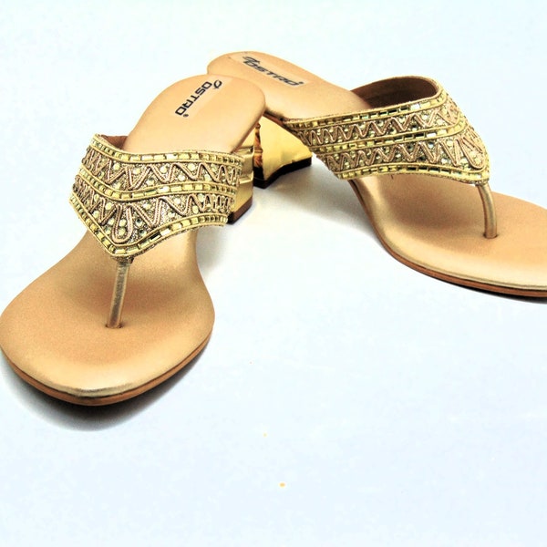 Slip in wedge heels in gold embroidered with crystals and rhinestones in a designer pattern.