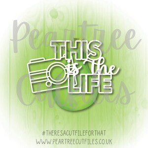 May include: White cut-out design of a camera and the text "This is the life" on a green pear-shaped background. The text "#theresacutfileforthat" and "www.peartreecutfiles.co.uk" are at the bottom of the image.