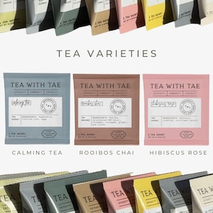 K&ouml;nnte beinhalten: Eine Auswahl an Teesachets in verschiedenen Farben, darunter Blau, Braun und Rosa. Jedes Sachet tr&auml;gt die Marke "Tea With Tae" und die Teesorte, wie "Calming Tea" und "Rooibos Chai". Das Bild zeigt auch den Text "Tea Varieties".