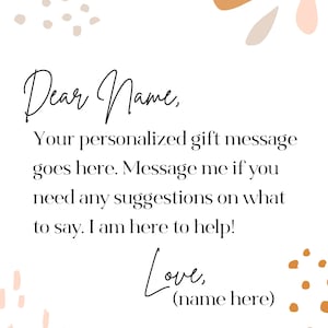 K&ouml;nnte beinhalten: Wei&szlig;er Hintergrund mit handschriftlichem Text: &bdquo;Liebe/r Name, Ihre personalisierte Geschenkmitteilung steht hier. Schreiben Sie mir, wenn Sie Vorschl&auml;ge brauchen. Ich helfe gerne! Liebe, (Name hier).&ldquo; Dekorative Formen.