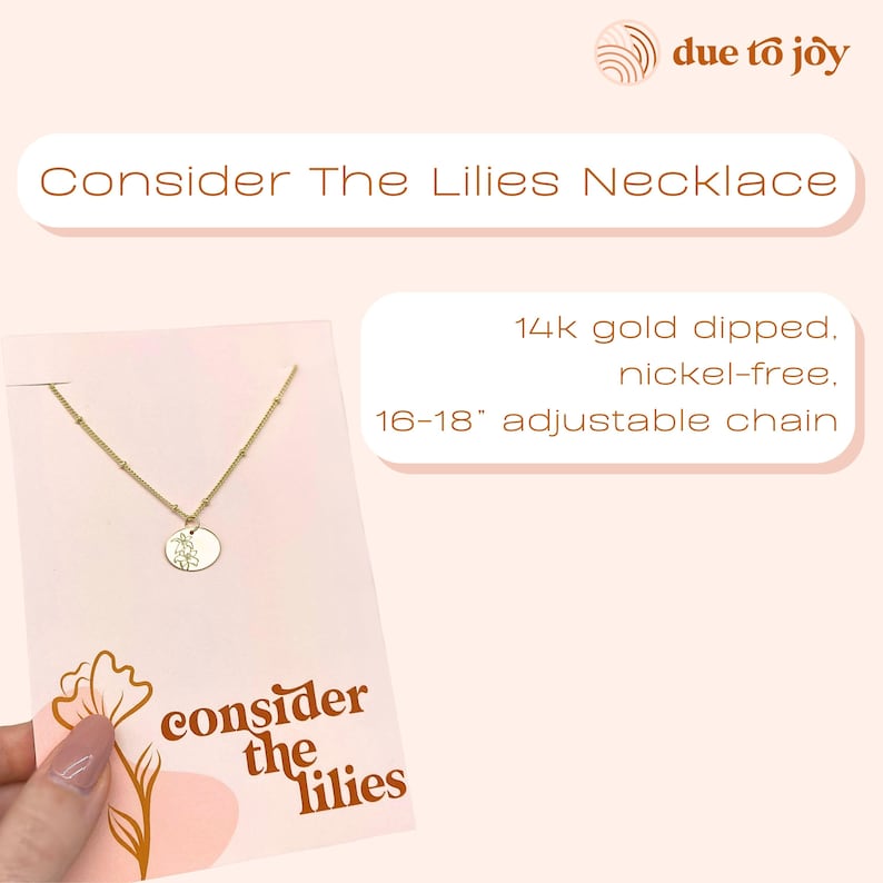 A pink card with a gold necklace with a lily on the charm