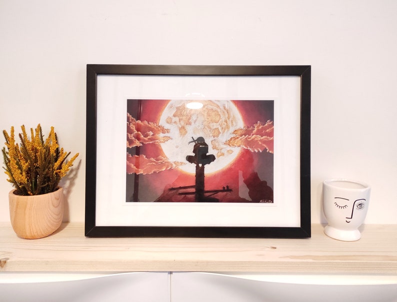 May include: Framed print of a black and white illustration of a figure standing on a platform with a large red moon in the background. The moon has a textured surface and is surrounded by clouds.