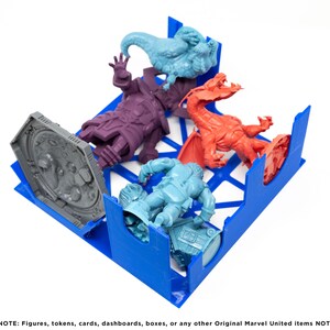May include: Blue plastic organizer with compartments for storing miniature figures. The organizer contains five figures: a gray figure, a purple figure, a blue figure, a red figure, and a light blue figure.