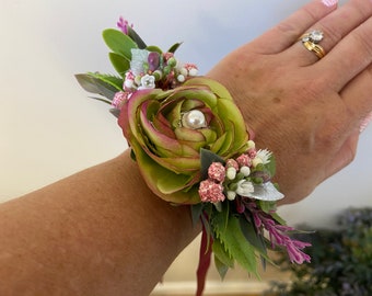 Corsage de poignet en forme de renoncule artificielle florale pour femme, vert pâle/magenta/cerise, réalisé sur un ruban de satin magenta. Livré dans une boîte de présentation.