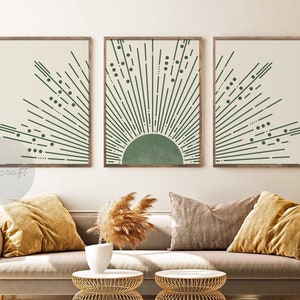 May include: Three framed prints with a minimalist design featuring a green sunburst pattern on a cream background. The sunburst pattern is made up of thin lines radiating outward from a central circle. The prints are arranged in a row, with the middle print featuring a larger circle in the center.