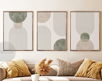 May include: Set of three abstract art prints with a minimalist design featuring arches, circles, and muted green and beige colors. The prints are framed in a light wood frame.