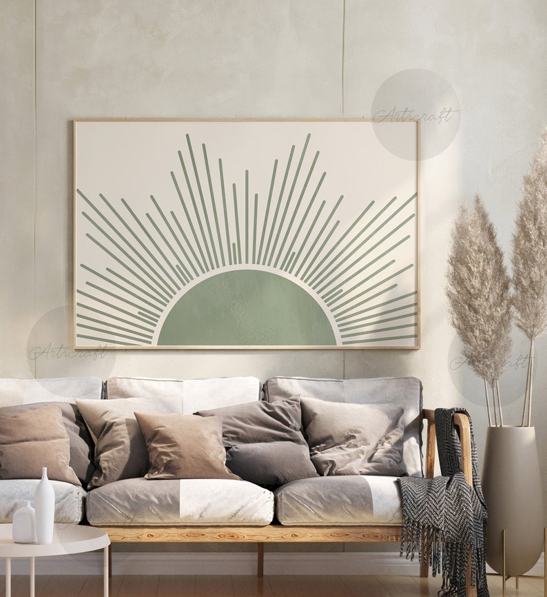 K&ouml;nnte beinhalten: Ein minimalistischer Sonnenstrahl-Druck in Gr&uuml;n und Wei&szlig; mit einem halbkreisf&ouml;rmigen Sonnendesign. Der Druck ist gerahmt und h&auml;ngt an einer Wand &uuml;ber einem Sofa mit Kissen.