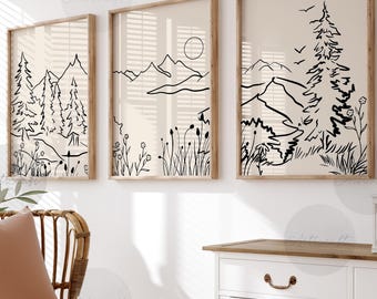 May include: Three framed black and white line drawings of a mountain landscape with trees and grass. The drawings are on a beige background and are in simple, minimalist style.