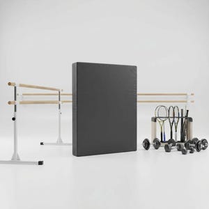 May include: A fitness studio setup featuring a black exercise mat, a ballet barre with wooden bars, and a collection of dumbbells and badminton rackets. The equipment is arranged against a white backdrop.