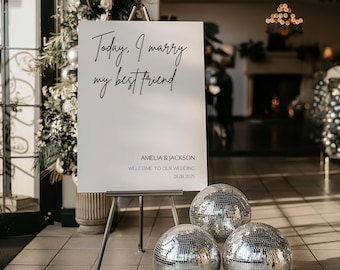 Puede incluir: Un cartel blanco con caligrafía negra que dice "Today. I marry my best friend." El cartel está en un caballete con tres bolas de discoteca plateadas delante de él. El cartel también incluye los nombres Amelia & Jackson, el texto "Welcome to our wedding" y la fecha 28.08.2025.
