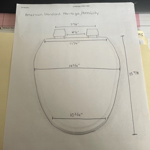 Puede incluir: Un diagrama dibujado a mano de un inodoro American Standard Heritage con medidas en pulgadas. El inodoro tiene 10 3/4 pulgadas de ancho, 14 3/4 pulgadas de alto y 15 7/8 pulgadas de adelante hacia atr&aacute;s. El asiento del inodoro tiene 11 1/4 pulgadas de ancho y 7 7/8 pulgadas de largo. El tanque del inodoro tiene 4 1/2 pulgadas de alto.